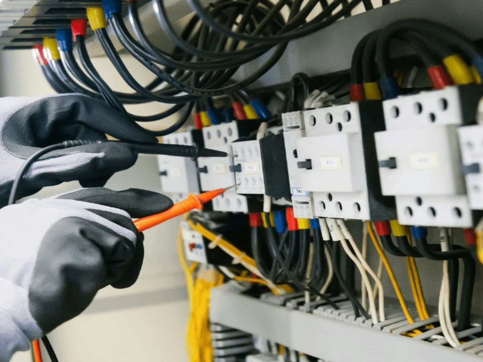 Técnico midiendo un tablero eléctrico con multímetro
