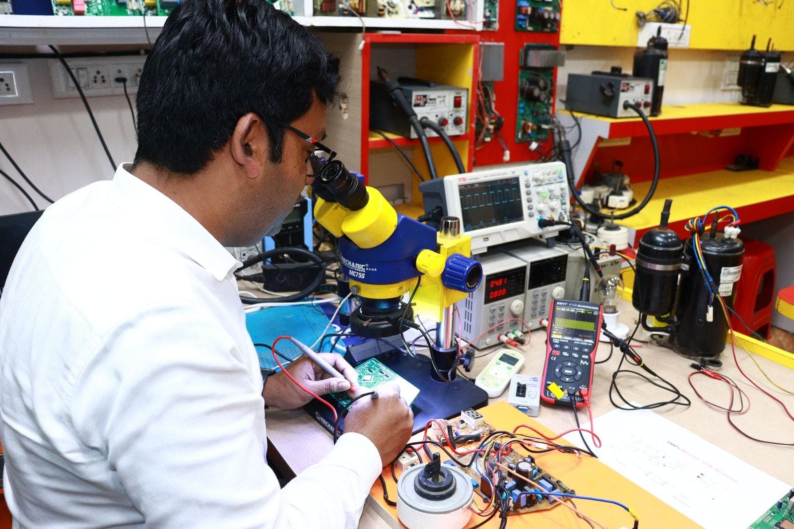 Técnico trabajando una tarjeta electrónica al microscopio